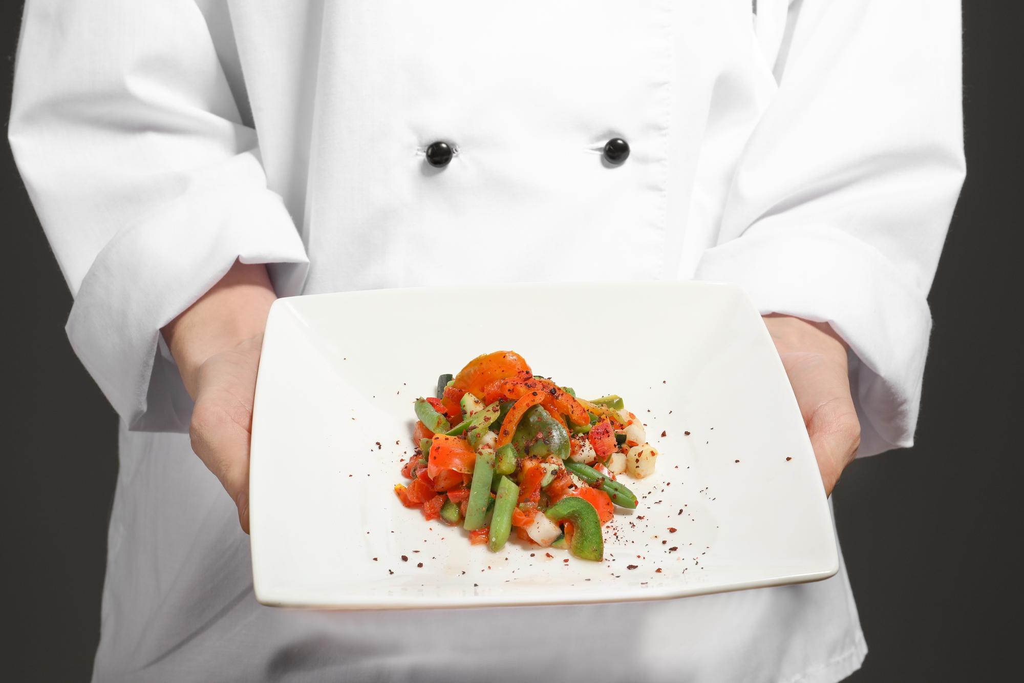 Instructor demonstrating plating on a modern kitchen counter